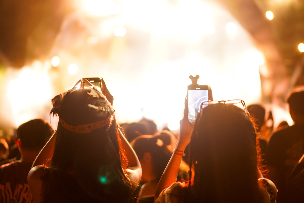 Young,Woman,Fan,In,Crowd,Taking,Photos,Or,Recording,Video